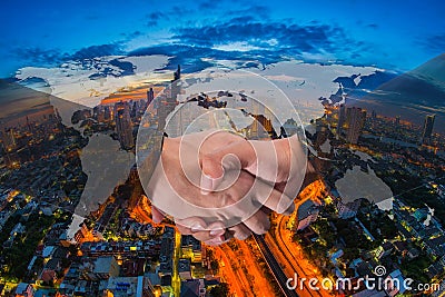 Double Exposure of a businessman handshake on World Global Cartography Globalization with Aerial view of cityscape at twilight, B Stock Photo