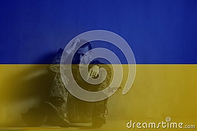 Double exposure of frustrated military soldier sitting crying alone in boot camp and Ukrainian flag. Stock Photo