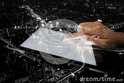 Double exposure hand using tablet and city on night Stock Photo