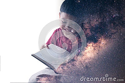 The double exposure image of the boy reading a book overlay with the milky way galaxy image. the concept of imagination, technolog Stock Photo