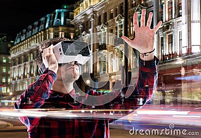 Double exposure, man wearing virtual reality goggles, night city Stock Photo