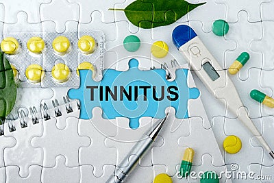 Double exposure. Puzzles with the image of tablets, a notebook, a thermometer and a pen with the inscription -TINNITUS Stock Photo