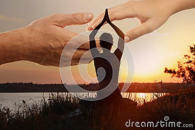 Double exposure of woman meditating and hands reaching each other outdoors at sunset. Yoga helping in daily life: harmony Stock Photo