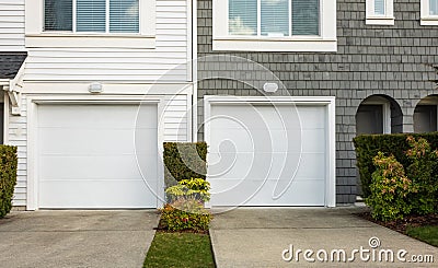 Double garage with short driveway. Wide Garage Door with concrete driveway in front in a perfect neighbourhood Stock Photo