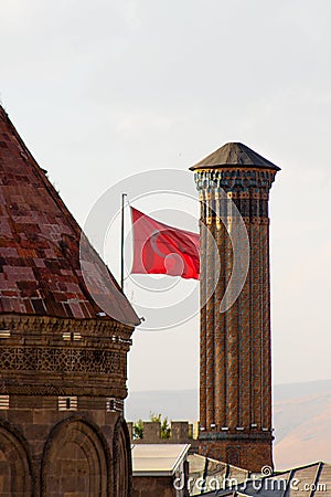 Double Minaret Madrasa ,Turkish flag in the background.Erzurum,Turkey Stock Photo