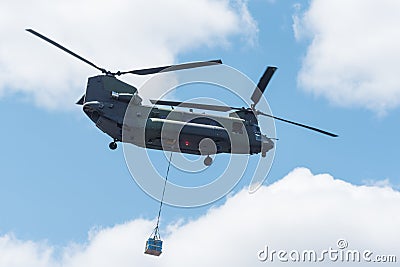 Double rotor, heavy airlift, military helicopter, in flight, carrying cargo. Stock Photo