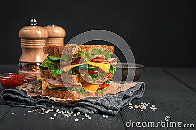 Double sandwich with ham, cheese and fresh vegetables on a black background. Stock Photo