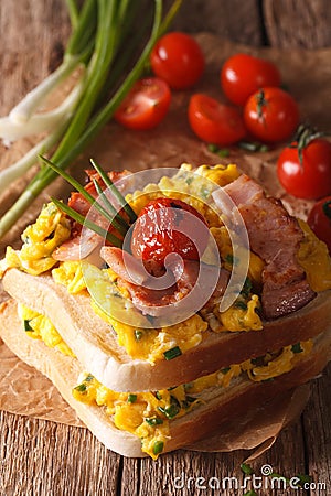 double sandwich with scrambled eggs, bacon and tomatoes close-up. vertical Stock Photo