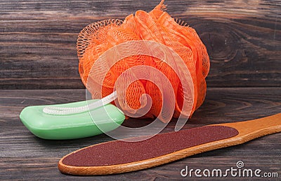 Double-sided grater for feet with soap and shower sponge on a wooden background Stock Photo