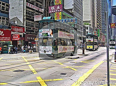 Double-storey-tram runs through a street in Hong Kong Editorial Stock Photo