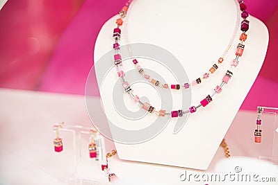 Double-stranded gemstone necklace and matching earrings on a white display stand Stock Photo