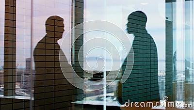 Double your success with collaboration. Silhouette shot of two businesspeople shaking hands inside an office building. Stock Photo