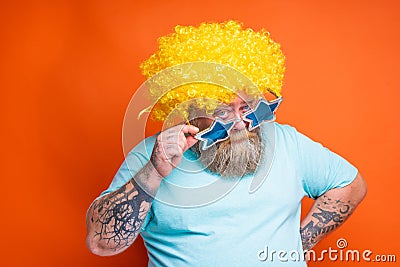 Fat doubter man with beard, tattoos and sunglasses has doubt about something Stock Photo