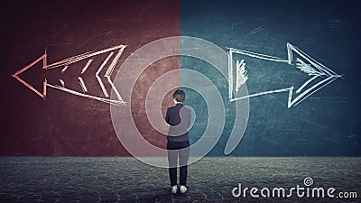 Doubtful businesswoman in front of a split wall as arrows leads in two different ways red and blue side. Correct choice left or Stock Photo