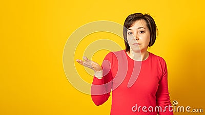 Doubtful indecisive woman raises palm with hesitation, faces difficult question or two choices, wears red sweater. Stock Photo