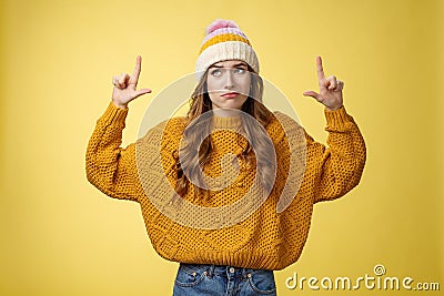 Doubtful unimpressed picky arrogant european girl 20s wearing hat sweater smirking hesitant displeased raising index Stock Photo