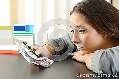 Doubtful woman looking to a lot of medicines Stock Photo