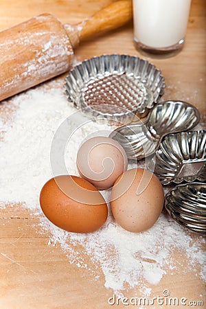 Dough baking ingredients, eggs, flour, milk and retro biscuit cutter Stock Photo