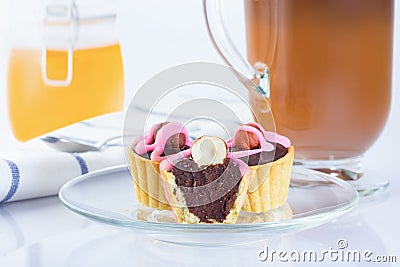 Dough baskets with chocolate and hazelnuts, pink iced cakes. Coffee in an Irish coffee glass, orange jam in a jar with a yoke. Lin Stock Photo