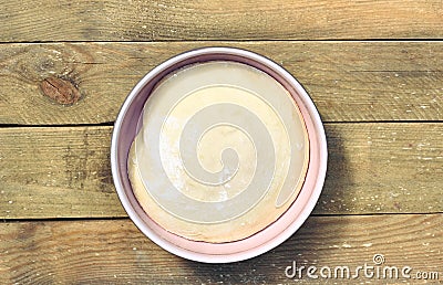 Dough in a pink bowl on rustic rough wooden table Stock Photo