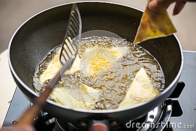 Dough sheet deep frying in very hot oil. Stock Photo