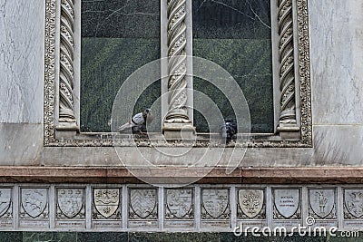 Dove birds couple on a window of a romanic marble church building Stock Photo