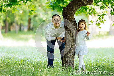 Down syndrome brother and adopted child playing outdoors Stock Photo