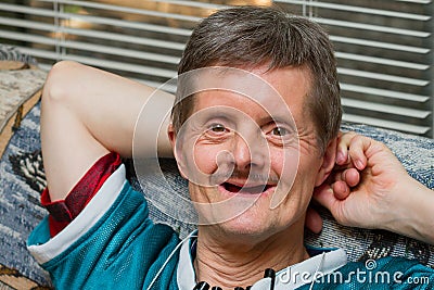 Down Syndrome Man No Teeth Leaning Back Smiling Stock Photo