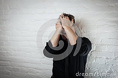 Downcast man holds his head as he suffers from depression and failure. Use it for a headache, money trouble or domestic violence Stock Photo