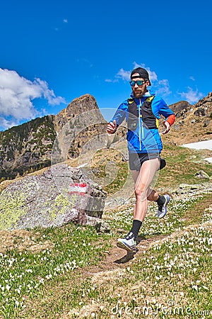 Downhill runner on reported mountain trail Stock Photo