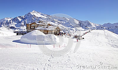 Downhill slope and apres ski mountain hut with restaurant terrace in the Italian Alps, Europe, Italy. Ski area Santa Caterina Stock Photo