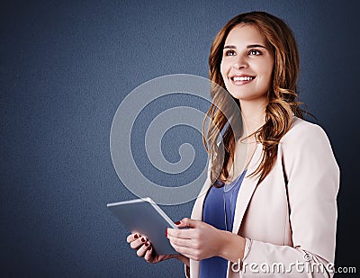 Downloading the latest must have business apps. Studio shot of an attractive young businesswoman using a digital tablet Stock Photo