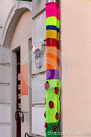 A downpipe wrapped in a colorful bright knitted fabric Stock Photo