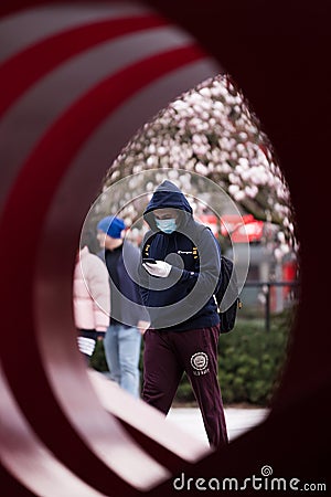 DOWNTOWN VANCOUVER, BC, CANADA - APR 01, 2020: Pedestrian in downtown Vancouver wearing a medical facemask and latex medical Editorial Stock Photo