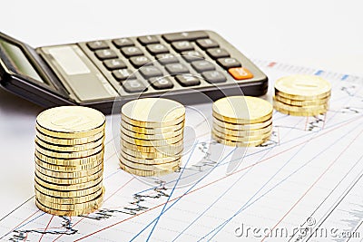 Downtrend stacks of coins, a calculator on the financial chart. Stock Photo