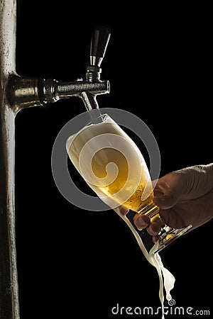 Draft beer overflows from the glass Stock Photo
