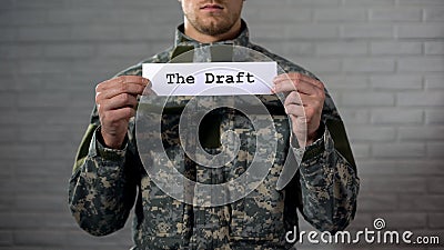 The draft written on sign in soldier hands, compulsory military service, duty Stock Photo