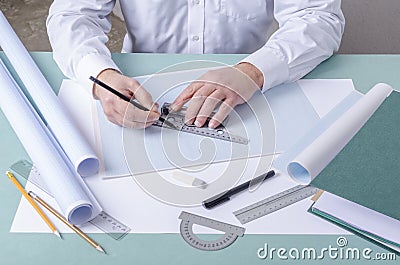 Draftsman using t-square and pencil for drafting on the graph paper. Professional constructor`s workplace Stock Photo
