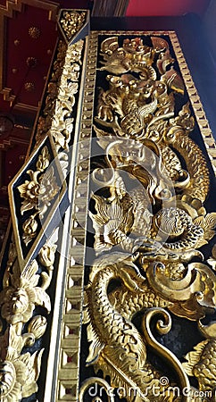 Dragon carving on temple windor cover with Thai Art design with Lacquer coated Real Gold Leaf in royal temple Bangkok Thailand Stock Photo