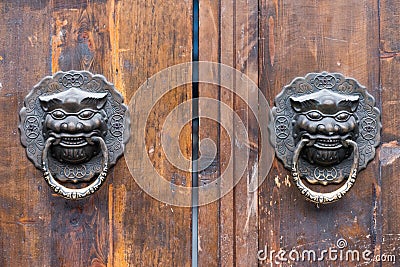 Dragon chinese door knocker on an old wooden gate Stock Photo