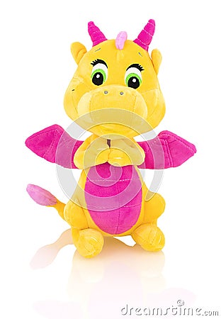 Dragon plushie doll isolated on white background with shadow reflection. Yellow stuffed dragon with purple horns and wings. Stock Photo