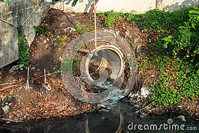 Drain pipe or effluent or sewer release wastewater into river. Stock Photo