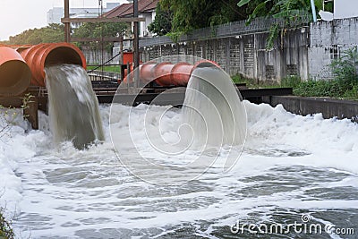 Drainage pipe with water flowing into the river Stock Photo