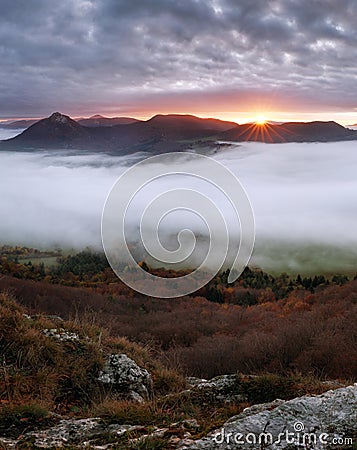 Dramatic autumn sunrise in mountain with red sky and clouds Stock Photo