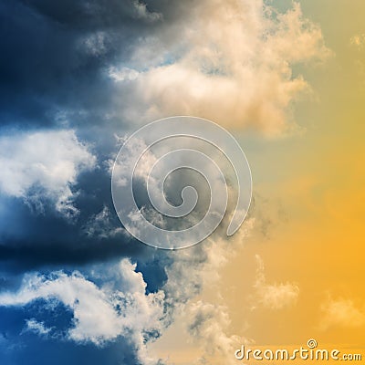 Dramatic blue thunderclouds and stunning yellow-golden fluffy clouds Stock Photo