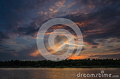 Dramatic clouds over water during sunset Stock Photo