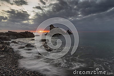Dramatic clouds at sunrise hovering over sea Stock Photo