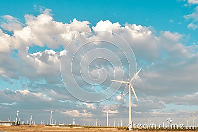 Dramatic cloudscape gather over wind energy field with many turbines Stock Photo