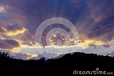 Dramatic heavenly cloudscape at sunset and silhouette of hillrange Stock Photo