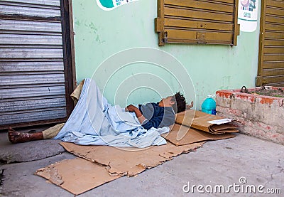 Dramatic image of homeless women sleeping in the sidewalk of a small caribbean town. Editorial Stock Photo